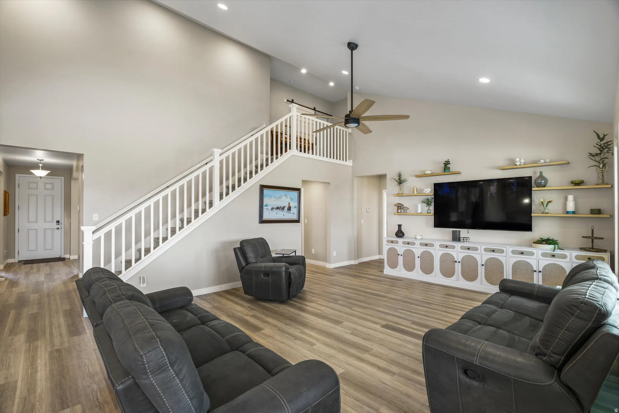 Living area featuring wood finished floors, ceiling fan, recessed lighting, and lofted ceiling