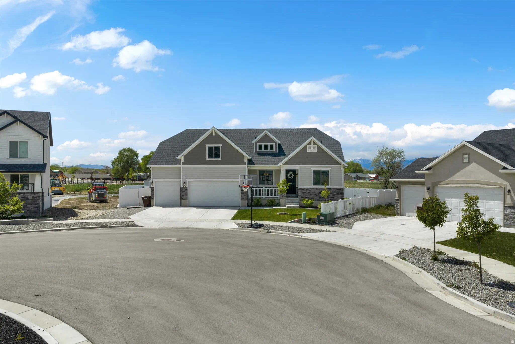 Craftsman-style home with covered porch, concrete driveway, and stone siding