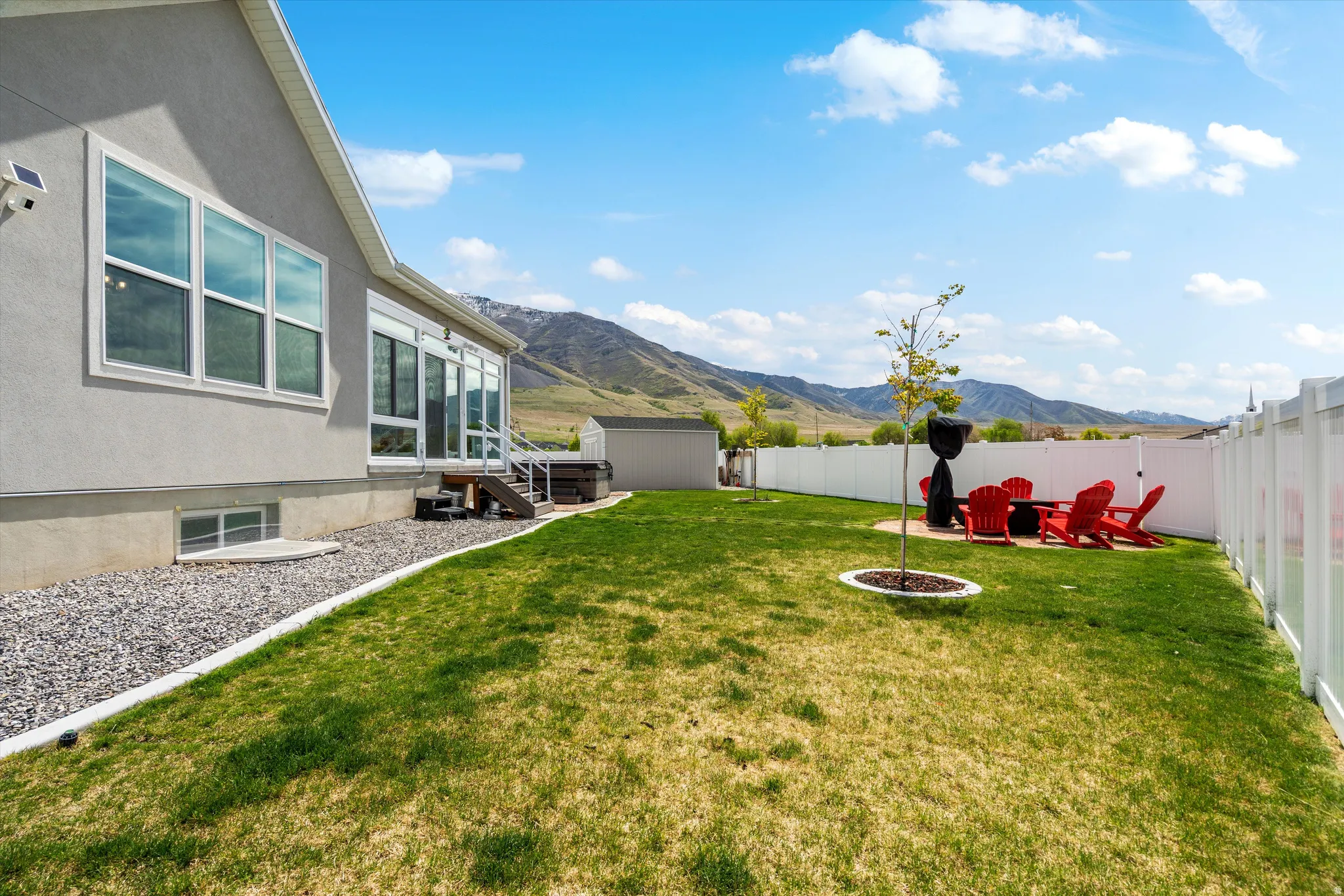 Fenced backyard with a mountain view, a storage unit, and an outdoor fire pit