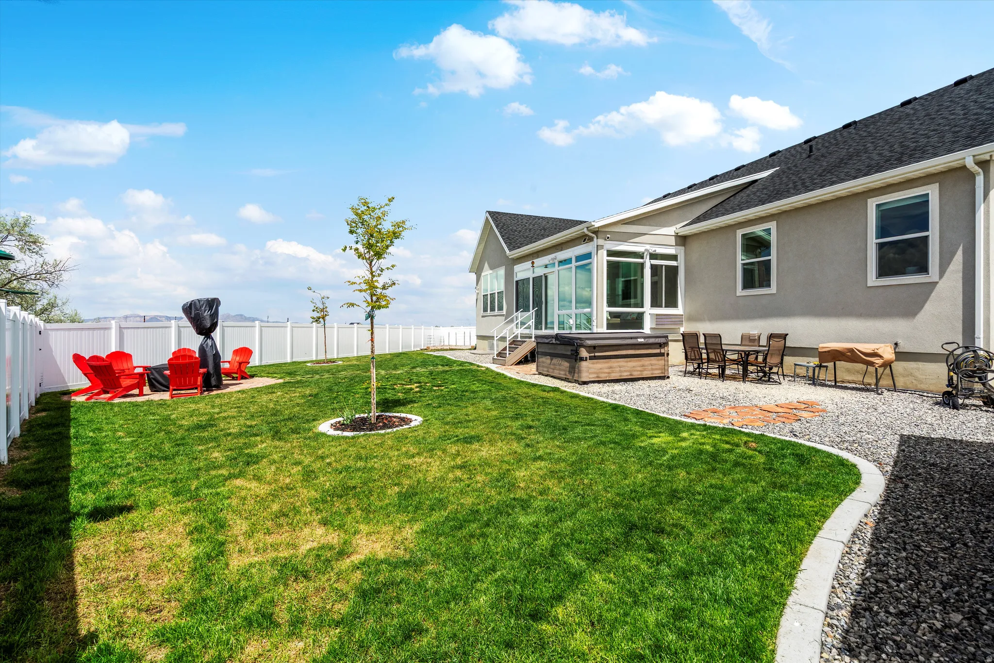 Fenced backyard featuring a sunroom and a patio