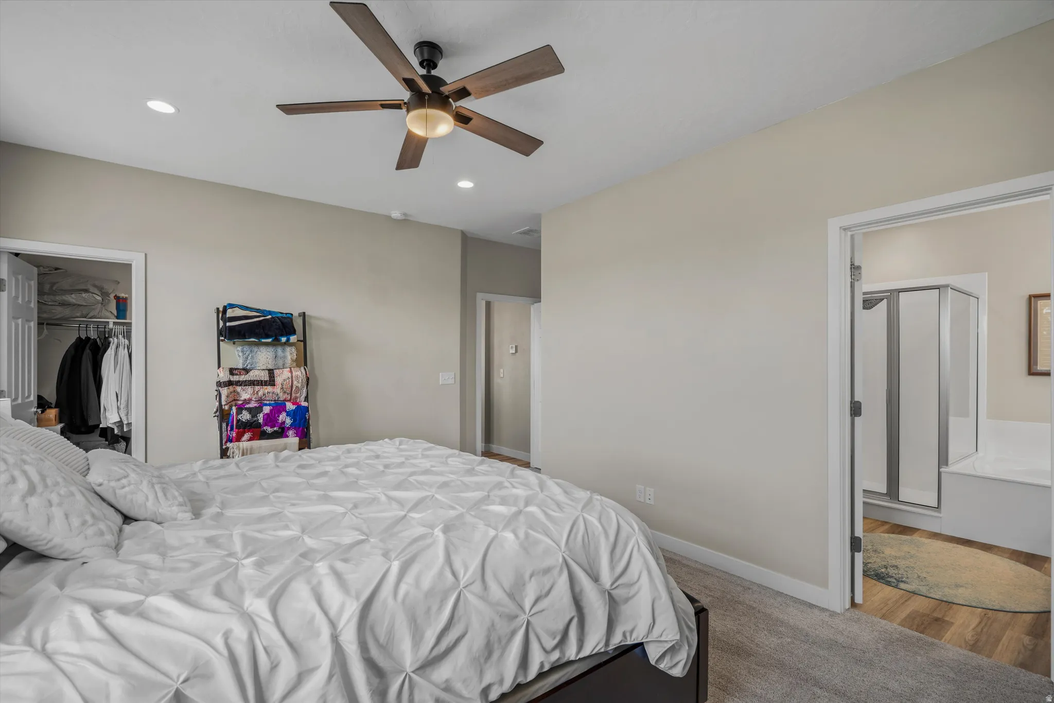 Bedroom featuring recessed lighting, a ceiling fan, a walk in closet, and light colored carpet