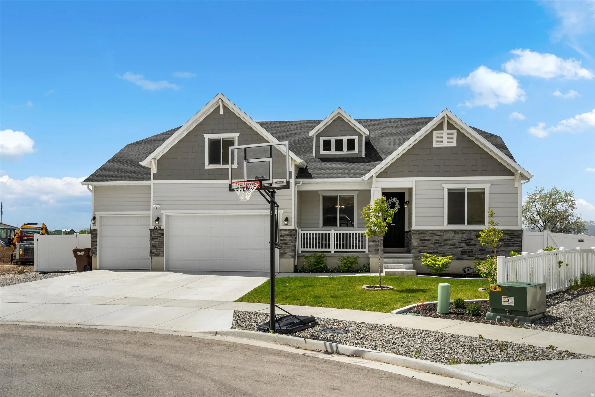 Craftsman house featuring stone siding, driveway, roof with shingles, a porch, and an attached garage
