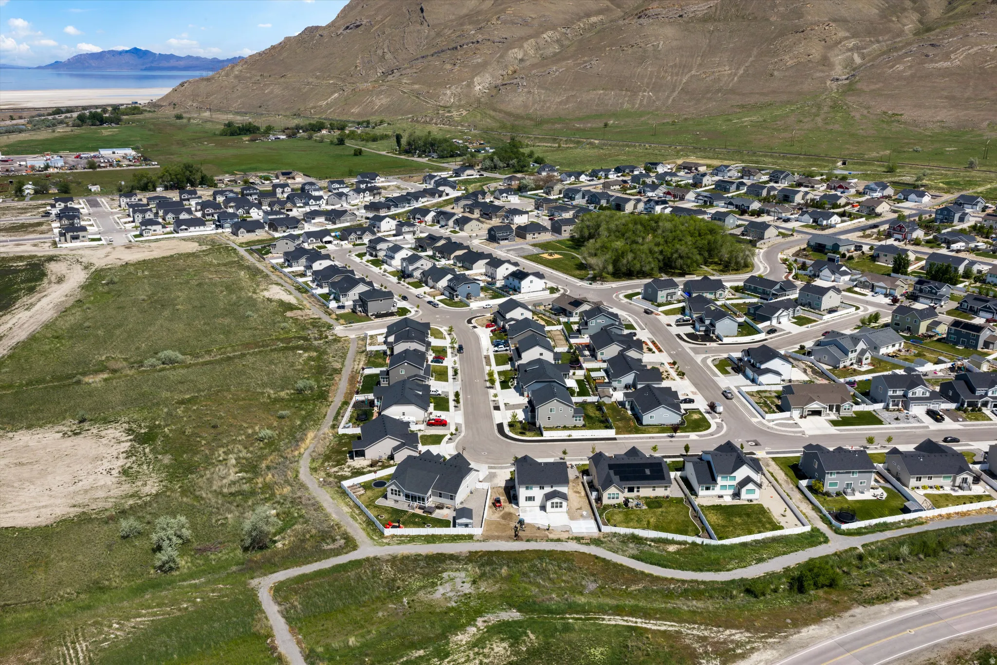 Aerial view of property and surrounding area with nearby suburban area and a mountainous background