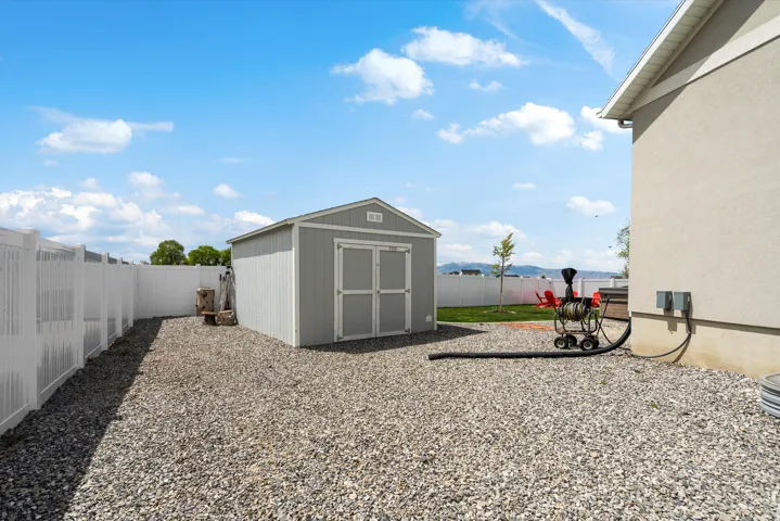 Fenced backyard with a storage unit and a mountain view