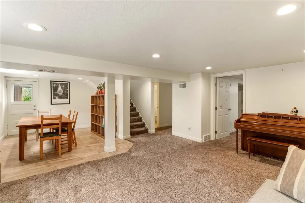 Game room with recessed lighting, light colored carpet, and a textured ceiling