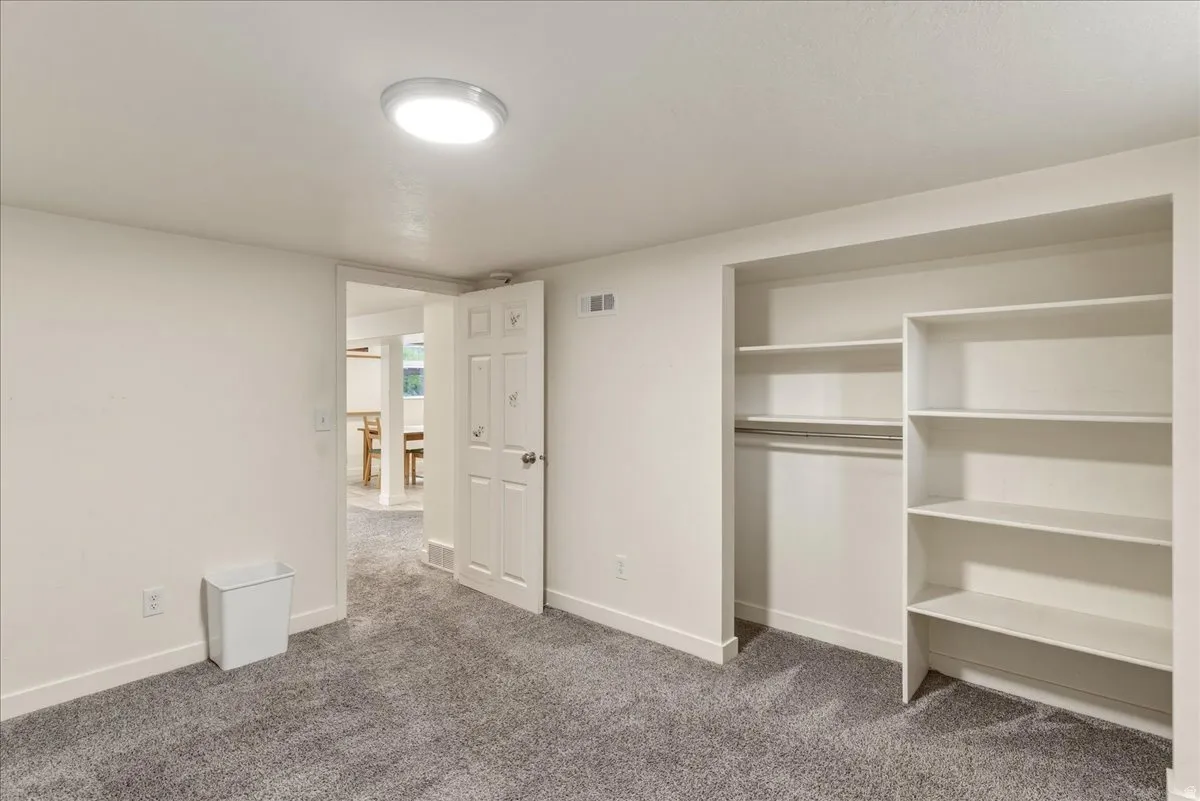 Unfurnished bedroom with a closet and dark colored carpet