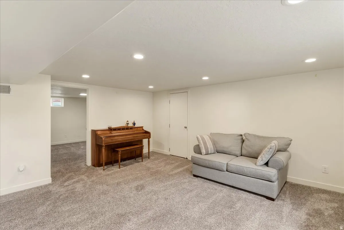 Living area with recessed lighting and carpet flooring