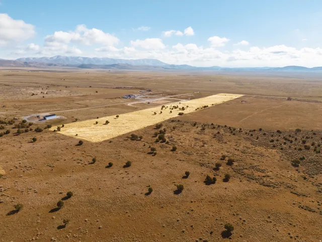 Aerial view of sparsely populated Cedar Valley area featuring a mountain backdrop and a desert landscape