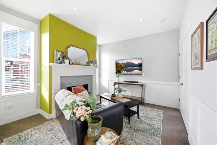 Carpeted bedroom featuring a decorative wall, a fireplace, recessed lighting, and wainscoting
