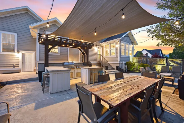 View of patio / terrace with an outdoor kitchen, a pergola, and an outdoor bar and dining area
