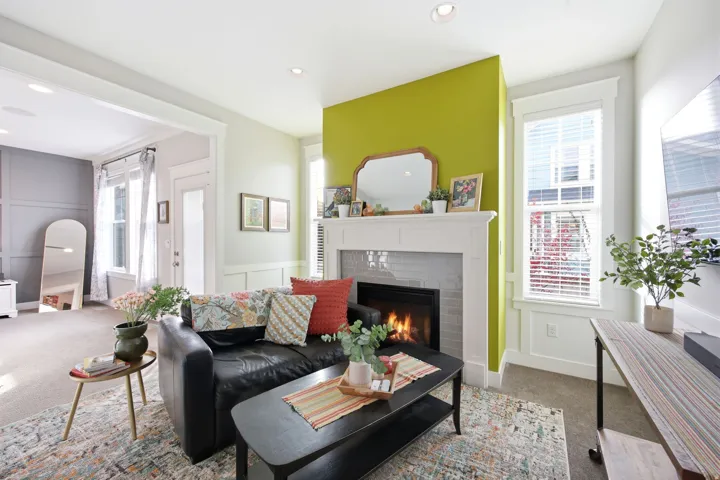 Living area with carpet floors, a tiled fireplace, recessed lighting, and a decorative wall
