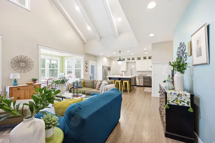 Living room featuring light wood-style flooring, vaulted ceiling, and recessed lighting
