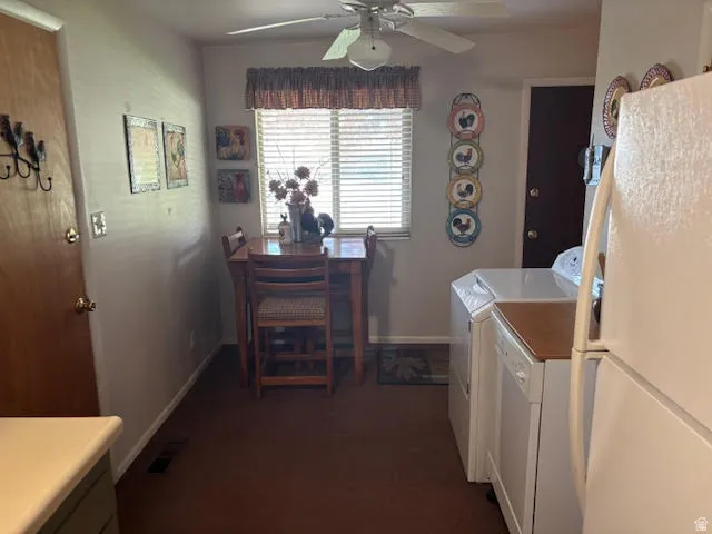 Laundry area with a ceiling fan, dark carpet, and washing machine and dryer