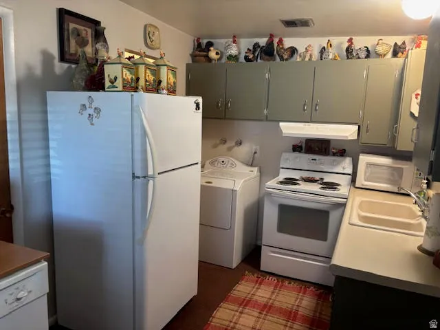 Kitchen featuring white appliances, washer / dryer, and light countertops
