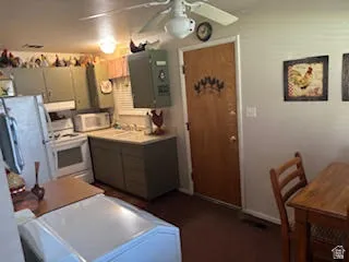 Kitchen featuring white appliances, ceiling fan, and light countertops