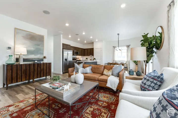 Open concept living area featuring recessed lighting, wood-finish flooring, and white walls