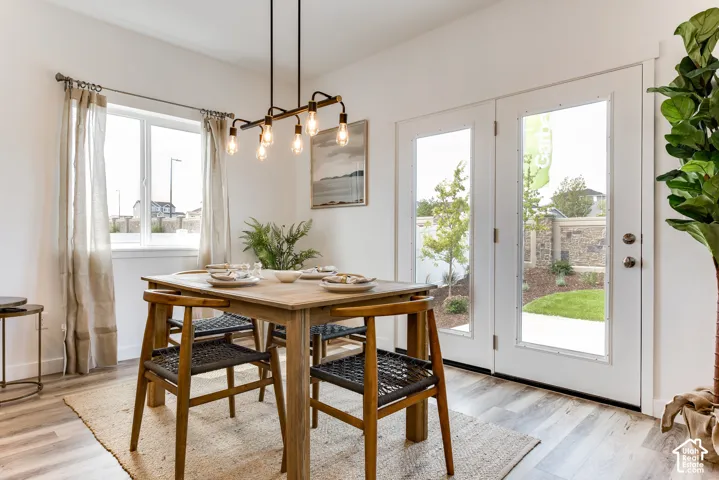 Wood-finish flooring, white walls, and a multi-bulb linear chandelier