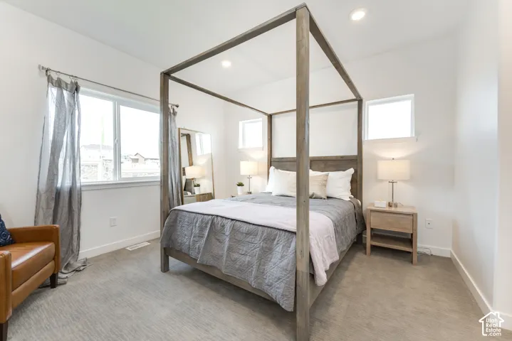 Recessed lighting, light-toned carpeting, multiple windows, and white walls