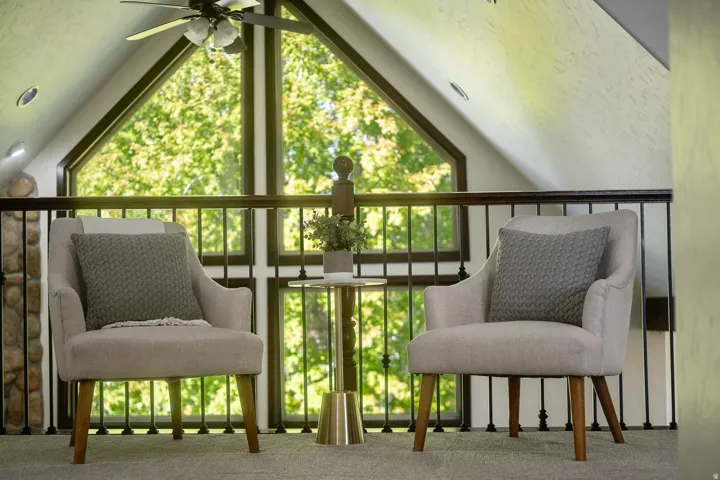 Sitting room featuring carpet, ceiling fan, plenty of natural light, and expansive windows