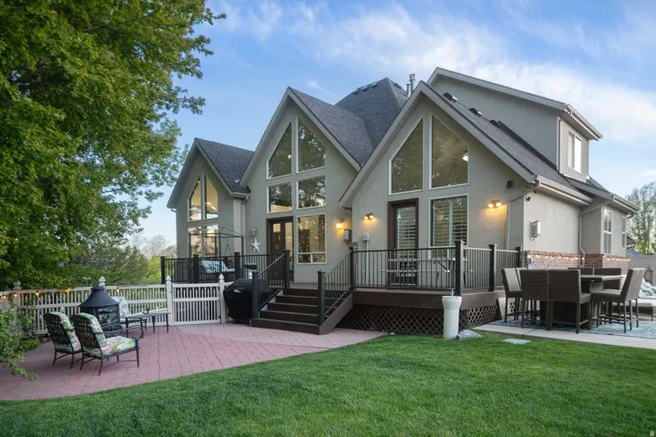 Rear view of property with a patio, a wooden deck, stucco siding, and outdoor dining area