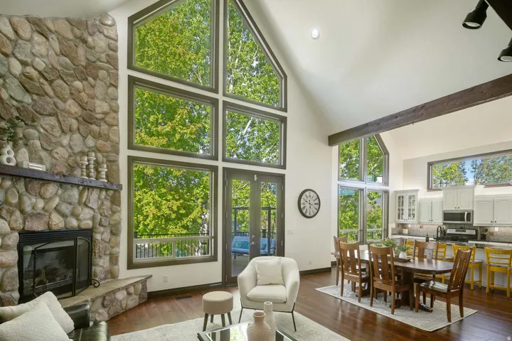 Living area featuring a stone fireplace, dark wood-style floors, and vaulted ceiling