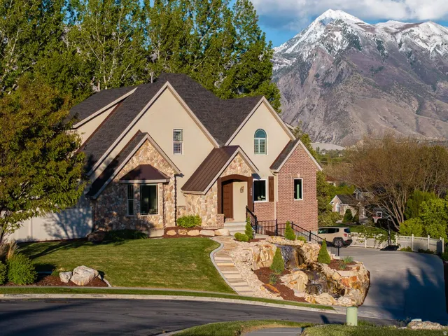 View of front of house featuring stone siding, stucco siding, and a mountain view