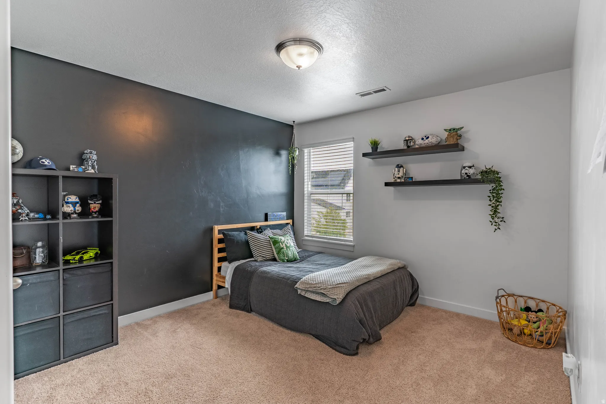 Bedroom with light colored carpet and a textured ceiling