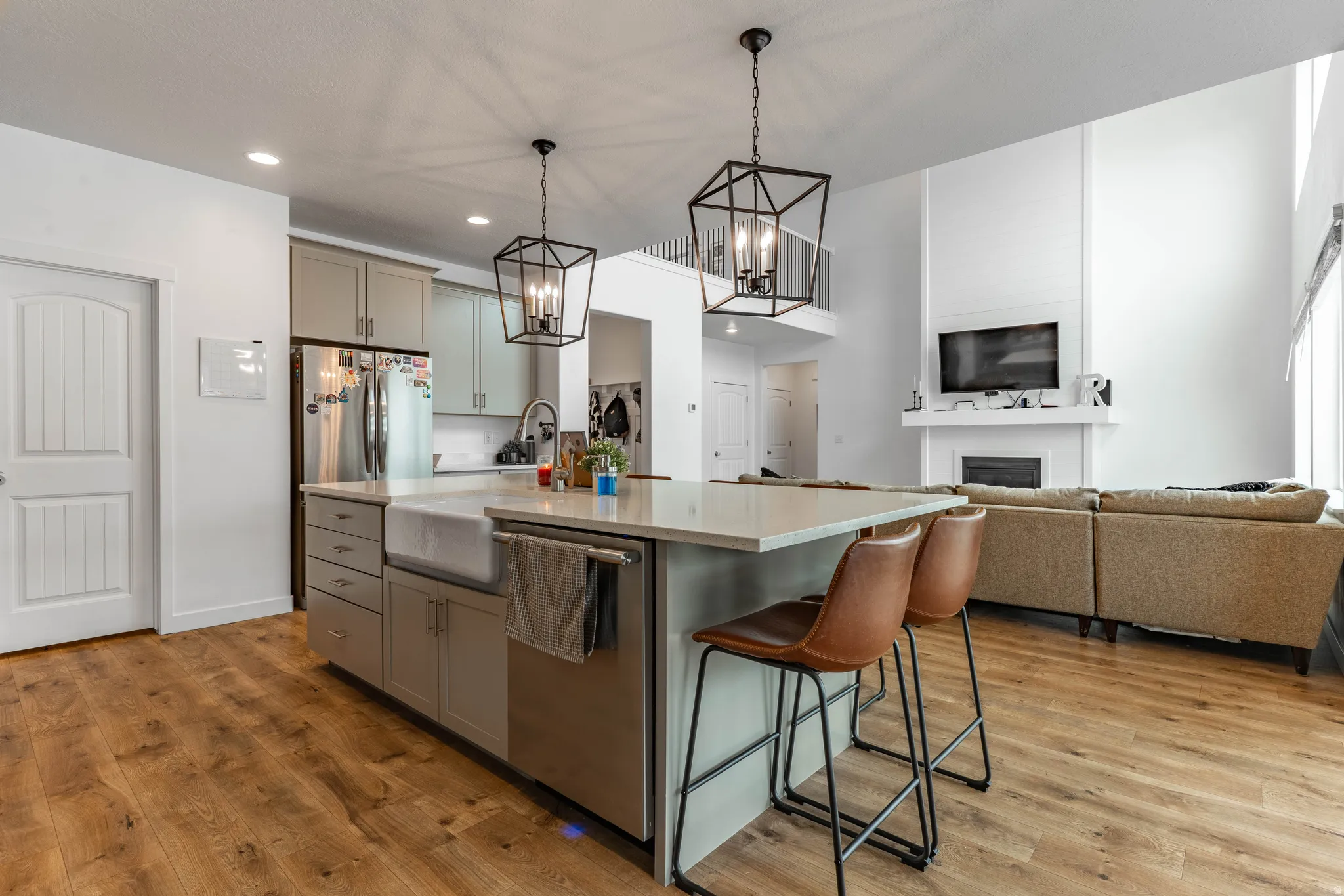 Kitchen with a breakfast bar, light wood-type flooring, hanging lights, a fireplace, and gray cabinetry