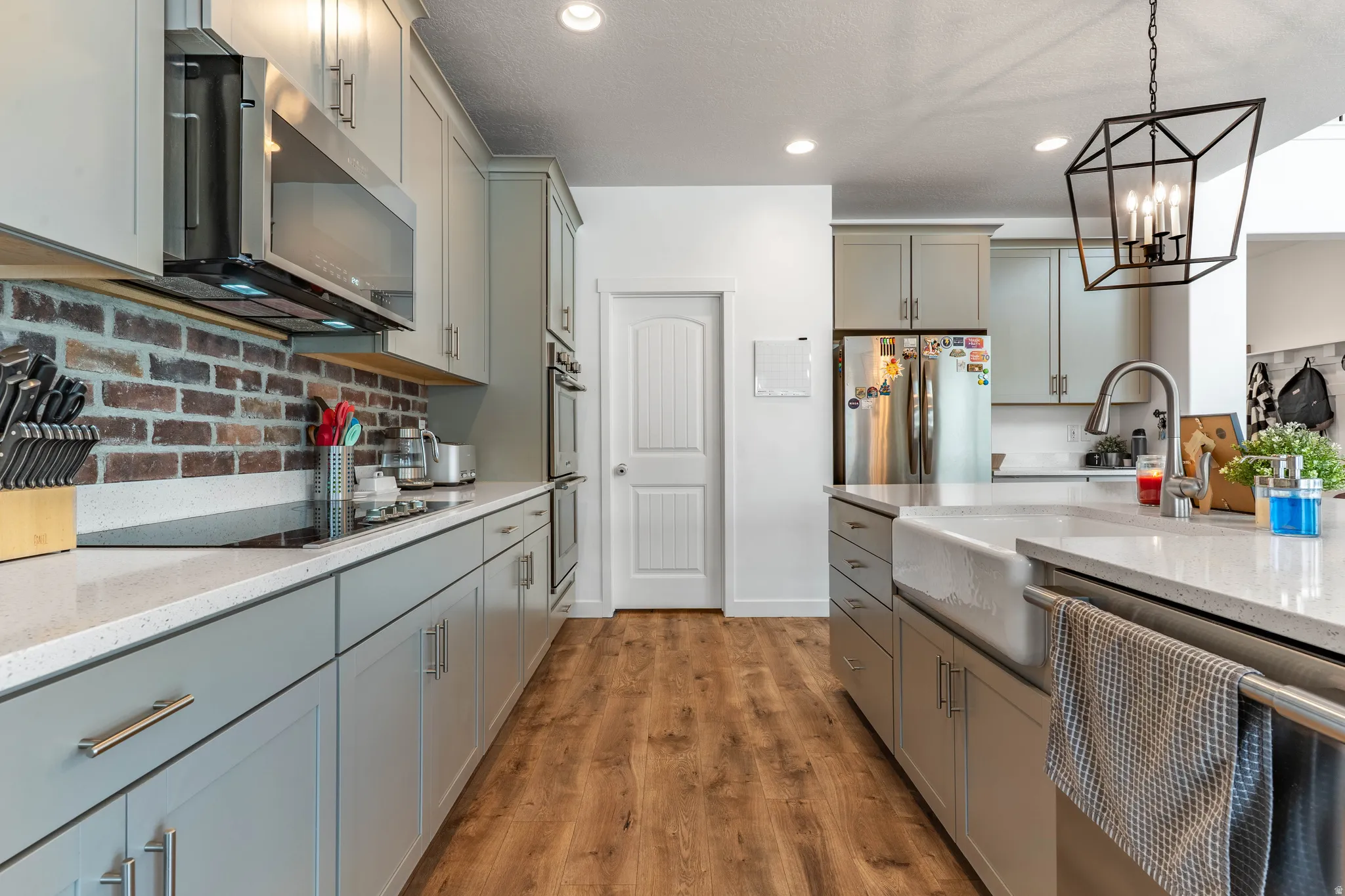 Kitchen featuring gray cabinets and light stone counters