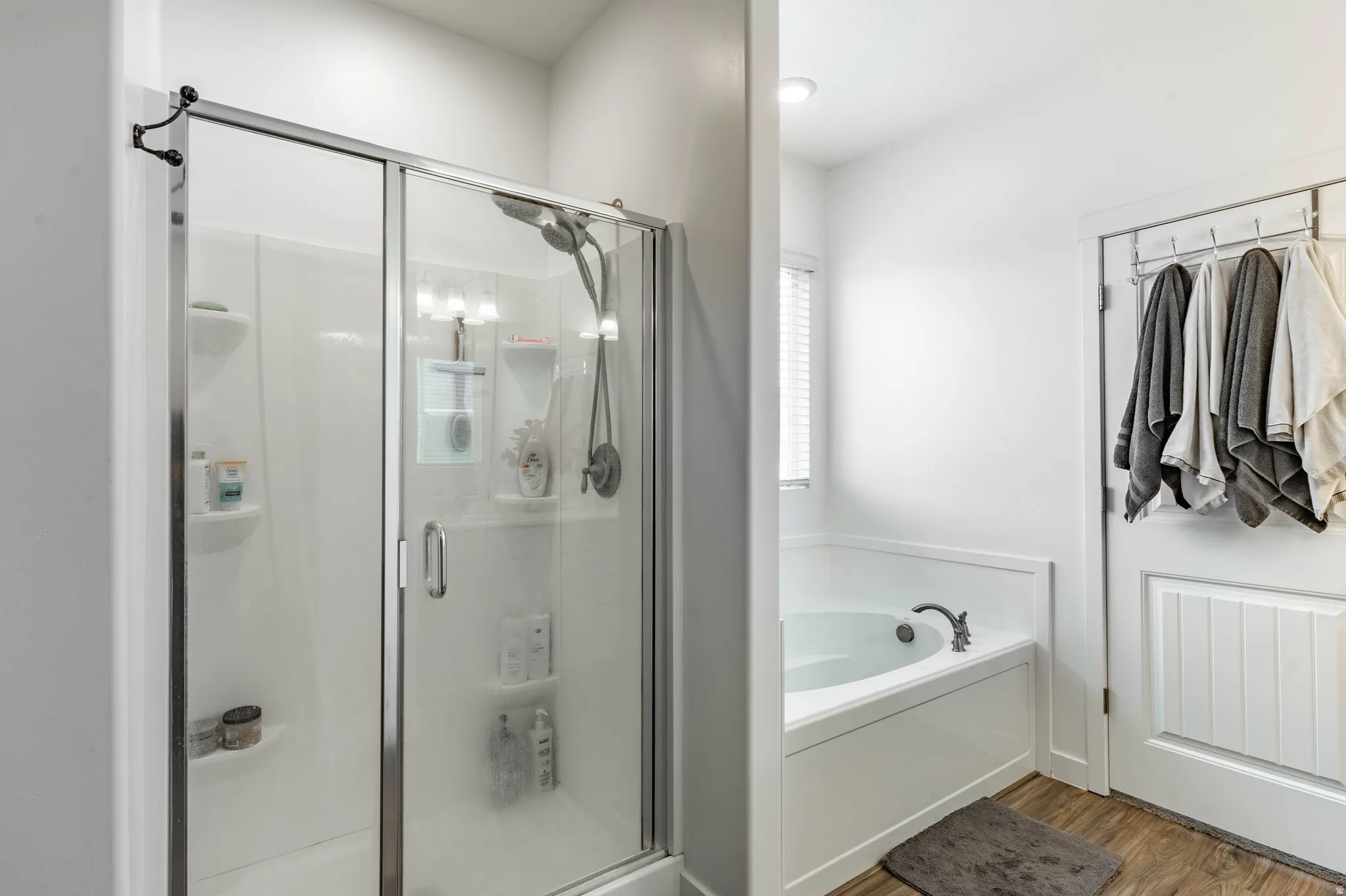 Bathroom with a stall shower, a bath, and light wood-style flooring