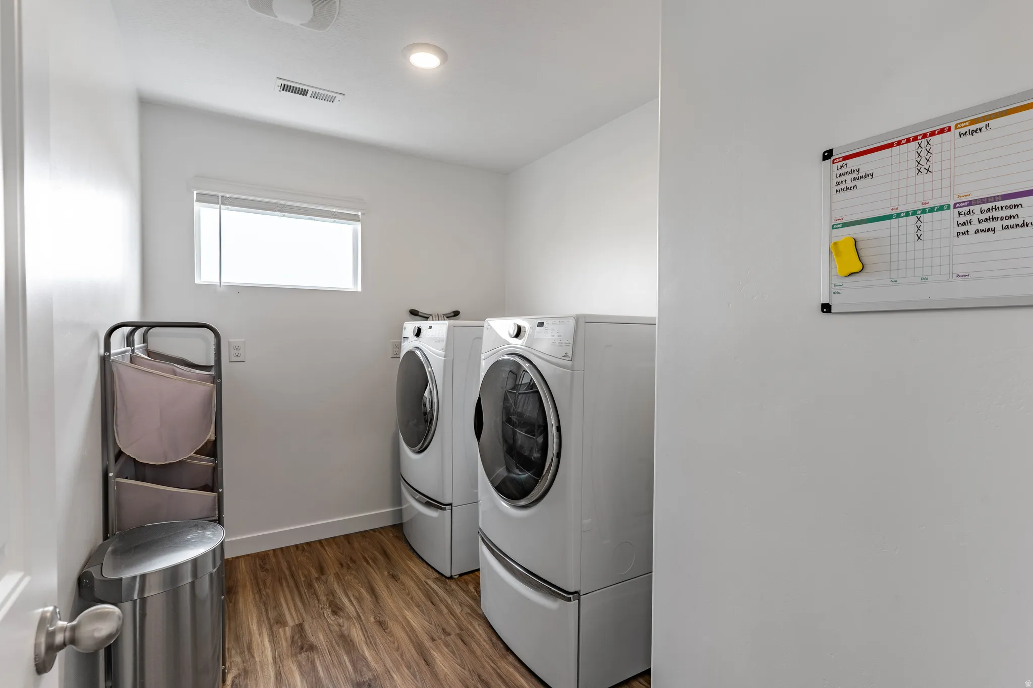 Laundry room with dark wood-type flooring and separate washer and dryer