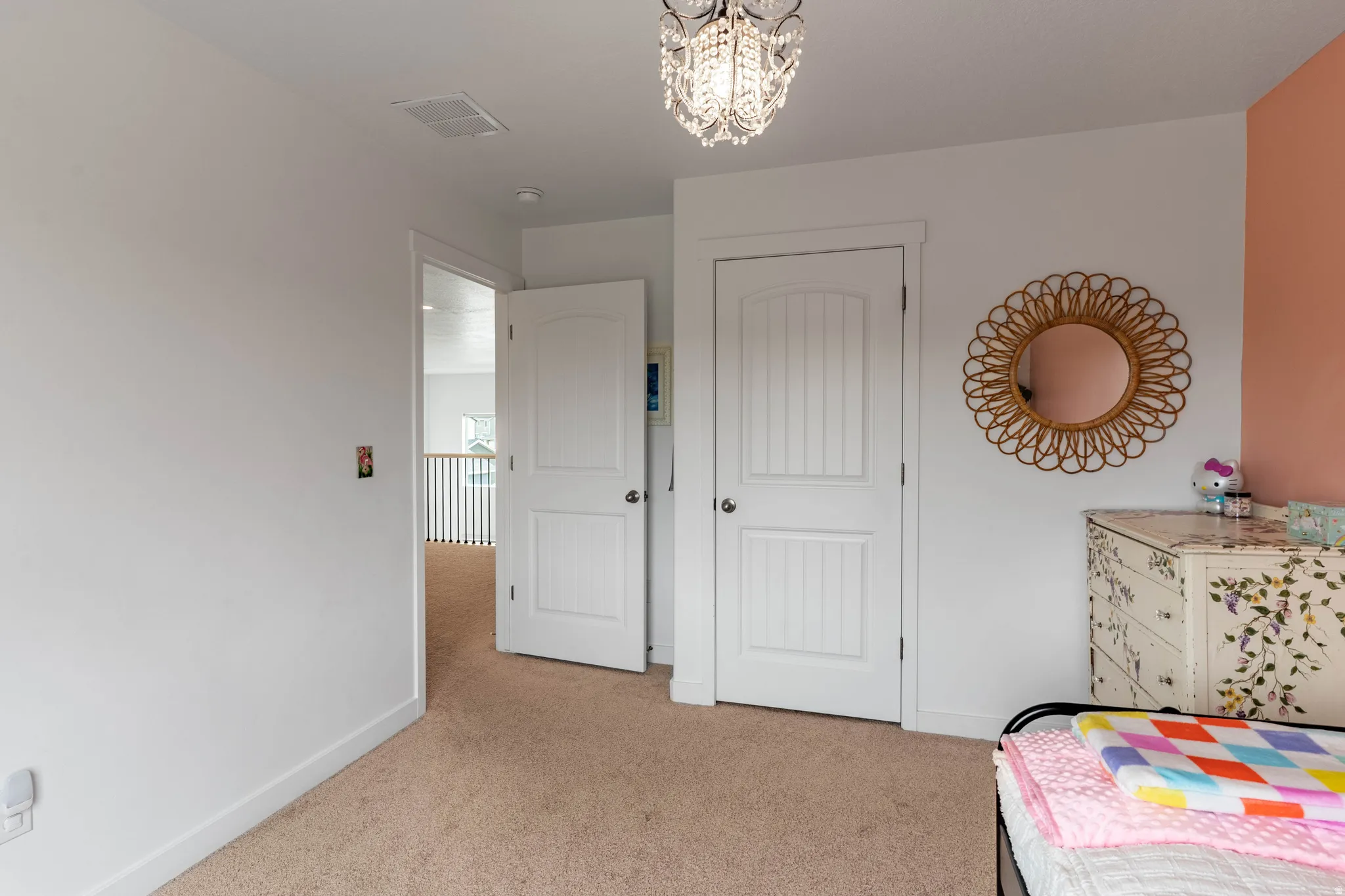 Bedroom with light carpet and a chandelier