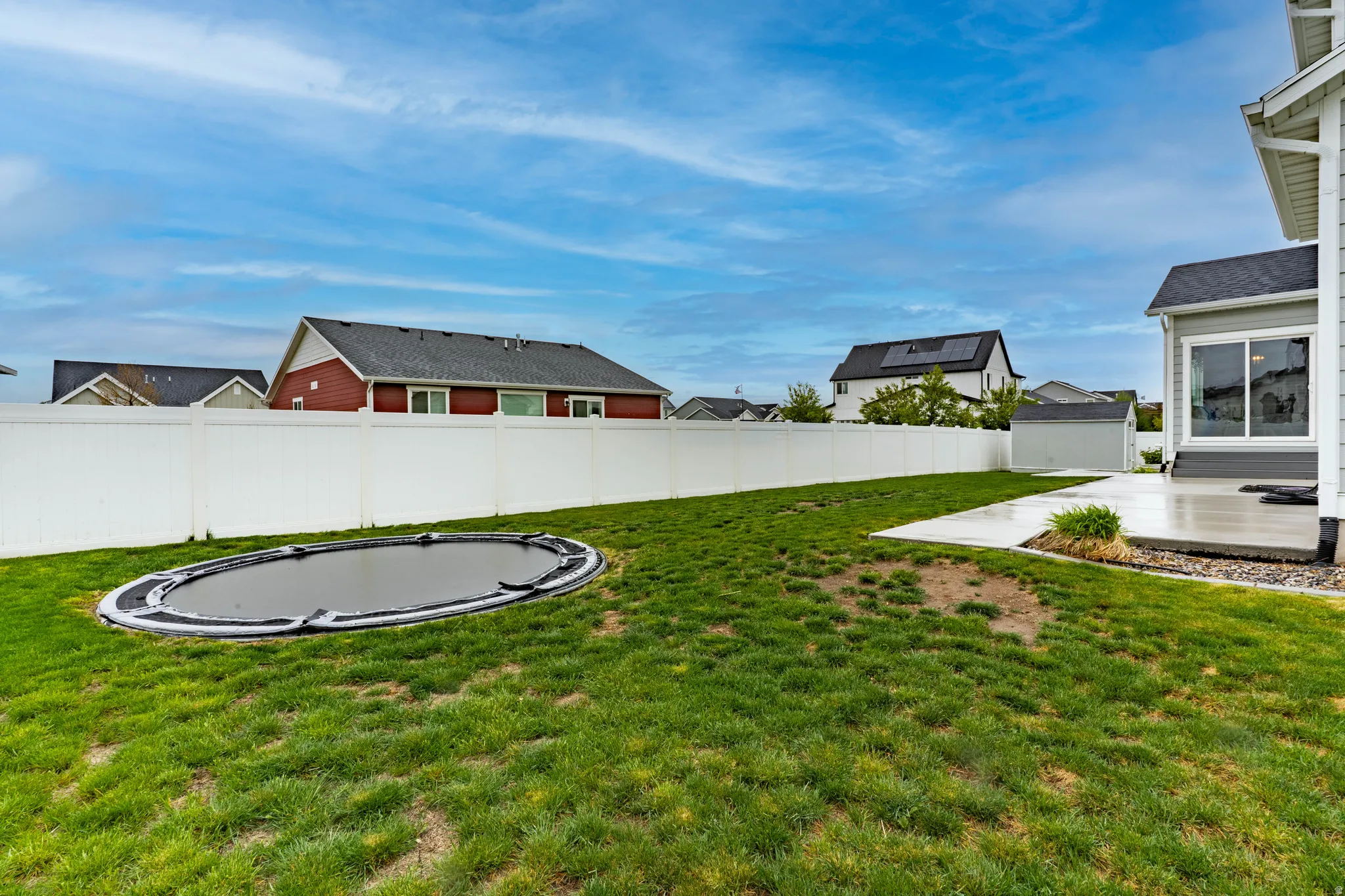 Fenced backyard with a patio and a trampoline