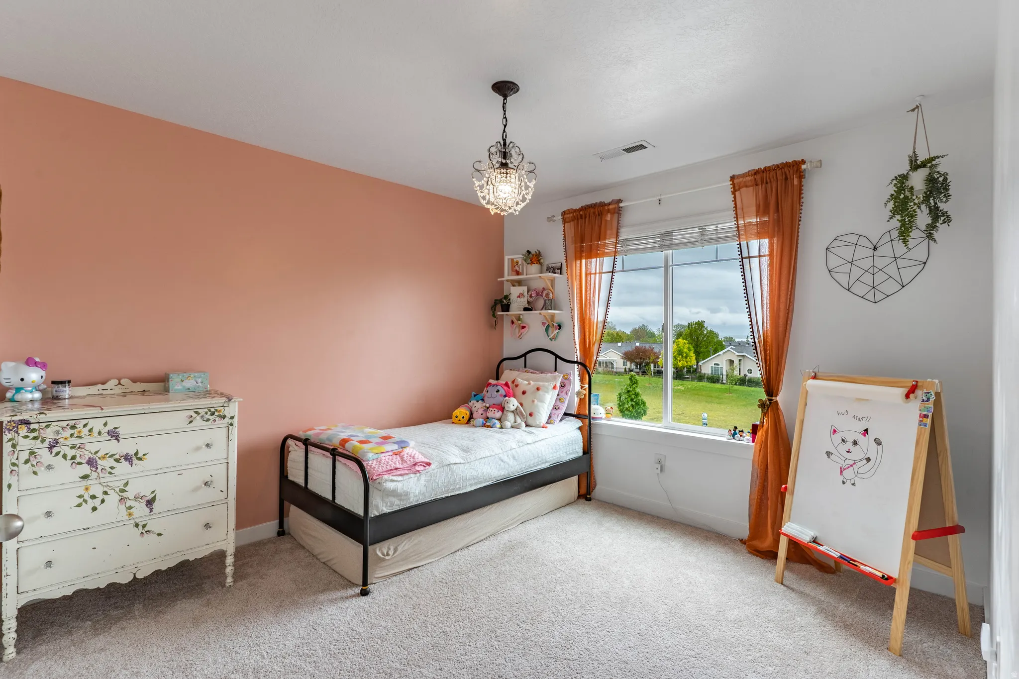 Bedroom with light carpet and hanging lights