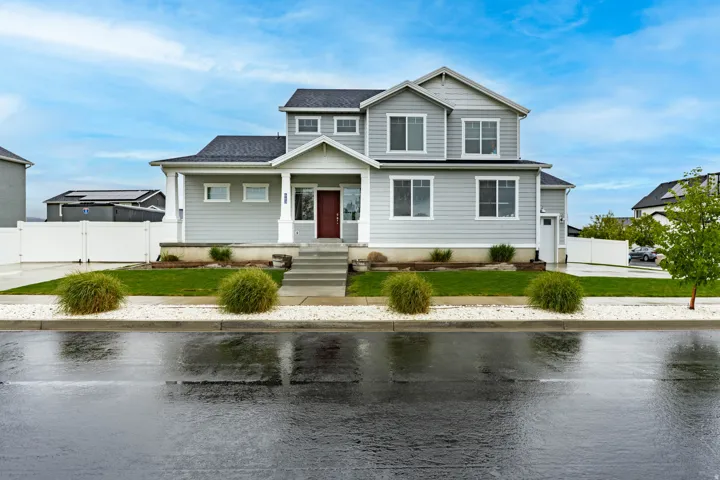 View of front of home featuring covered porch, a gate, and a water view
