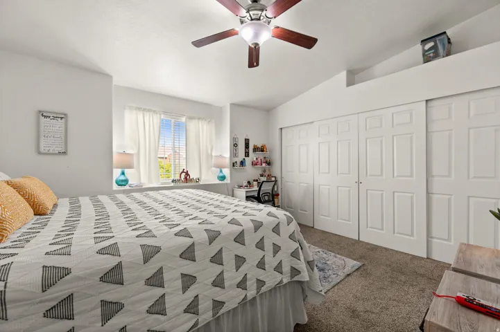 Bedroom with carpet flooring, vaulted ceiling, a ceiling fan, and a closet