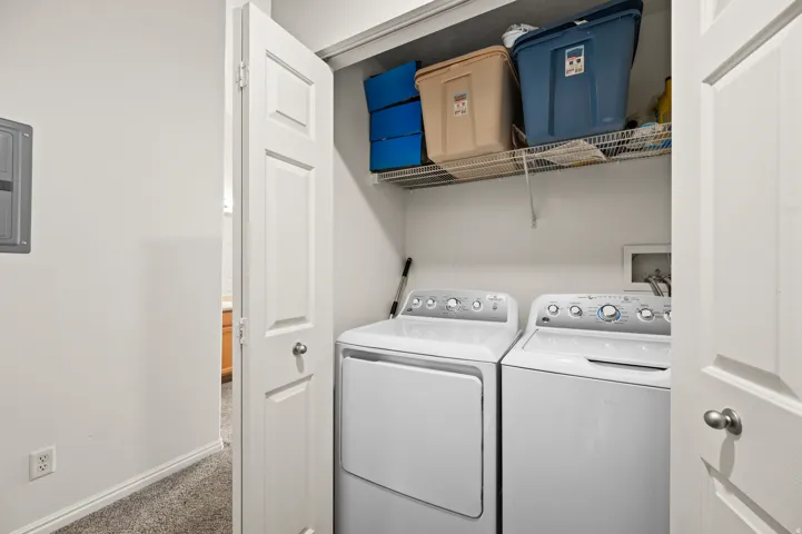 Laundry area featuring independent washer and dryer, dark carpet, and electric panel