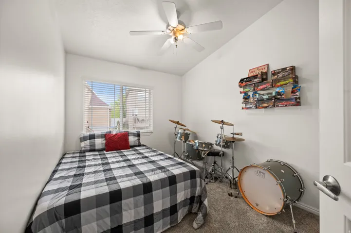 Bedroom featuring lofted ceiling, carpet floors, and a ceiling fan