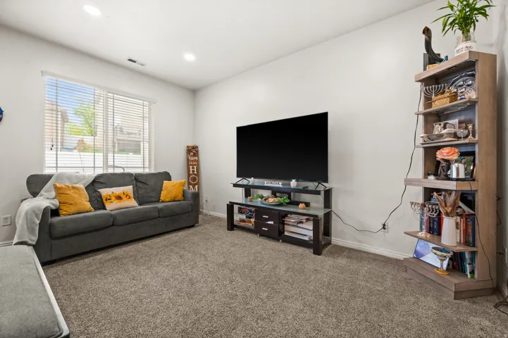 Carpeted living area with recessed lighting and baseboards