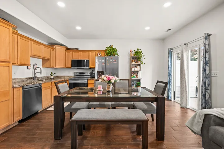 Kitchen with stainless steel appliances, light stone countertops, dark wood-type flooring, and recessed lighting