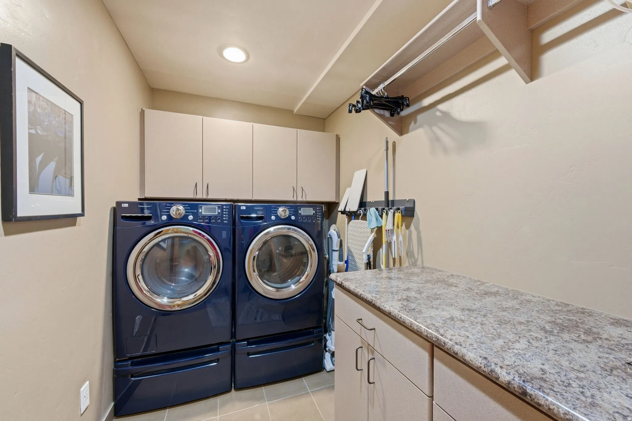 Laundry area featuring cabinet space, washer and clothes dryer, and light tile patterned floors