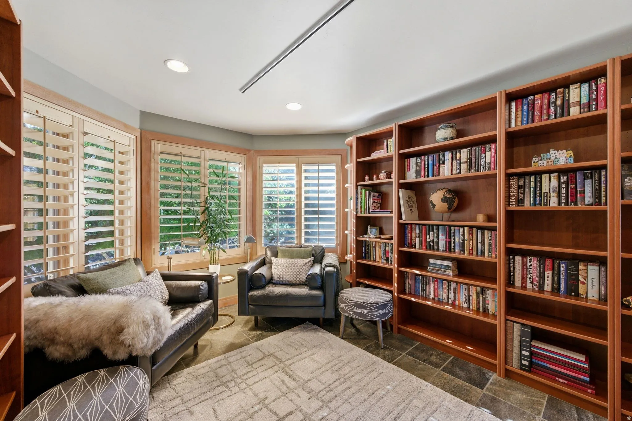 Sitting room with dark stone finish flooring and recessed lighting