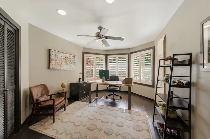 Office space featuring dark wood-style flooring and a ceiling fan