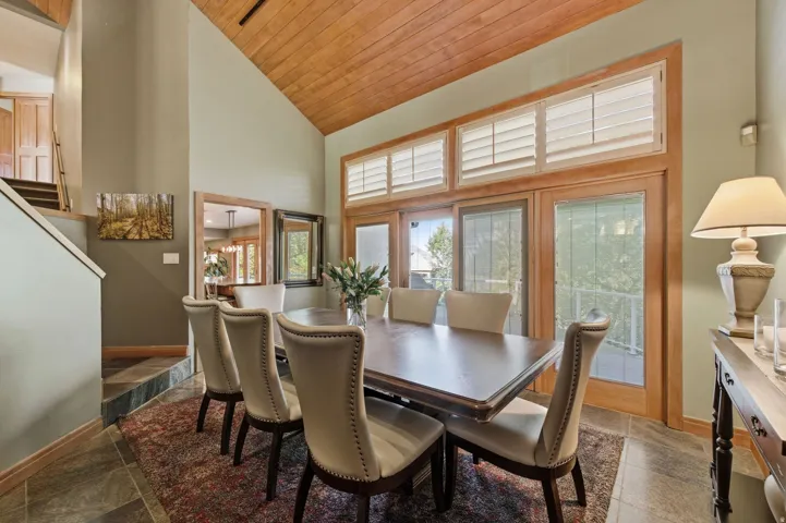 Dining space featuring a vaulted wood ceiling and stone tile flooring