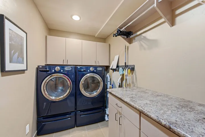 Laundry area featuring cabinet space, washer and clothes dryer, and light tile patterned floors