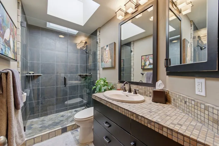 Bathroom with decorative backsplash, vanity, and a stall shower