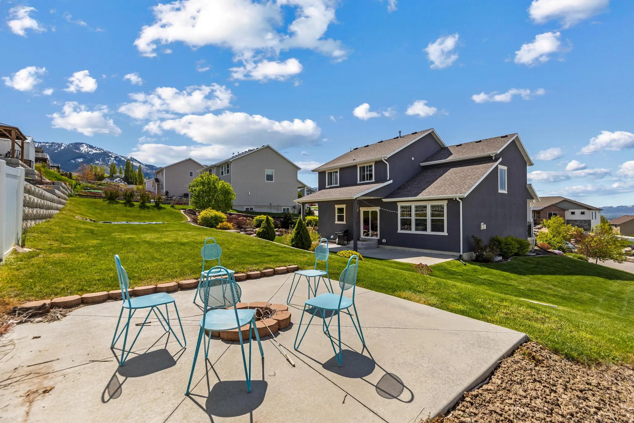 Back of house featuring a patio area, a residential view, a fire pit, and roof with shingles