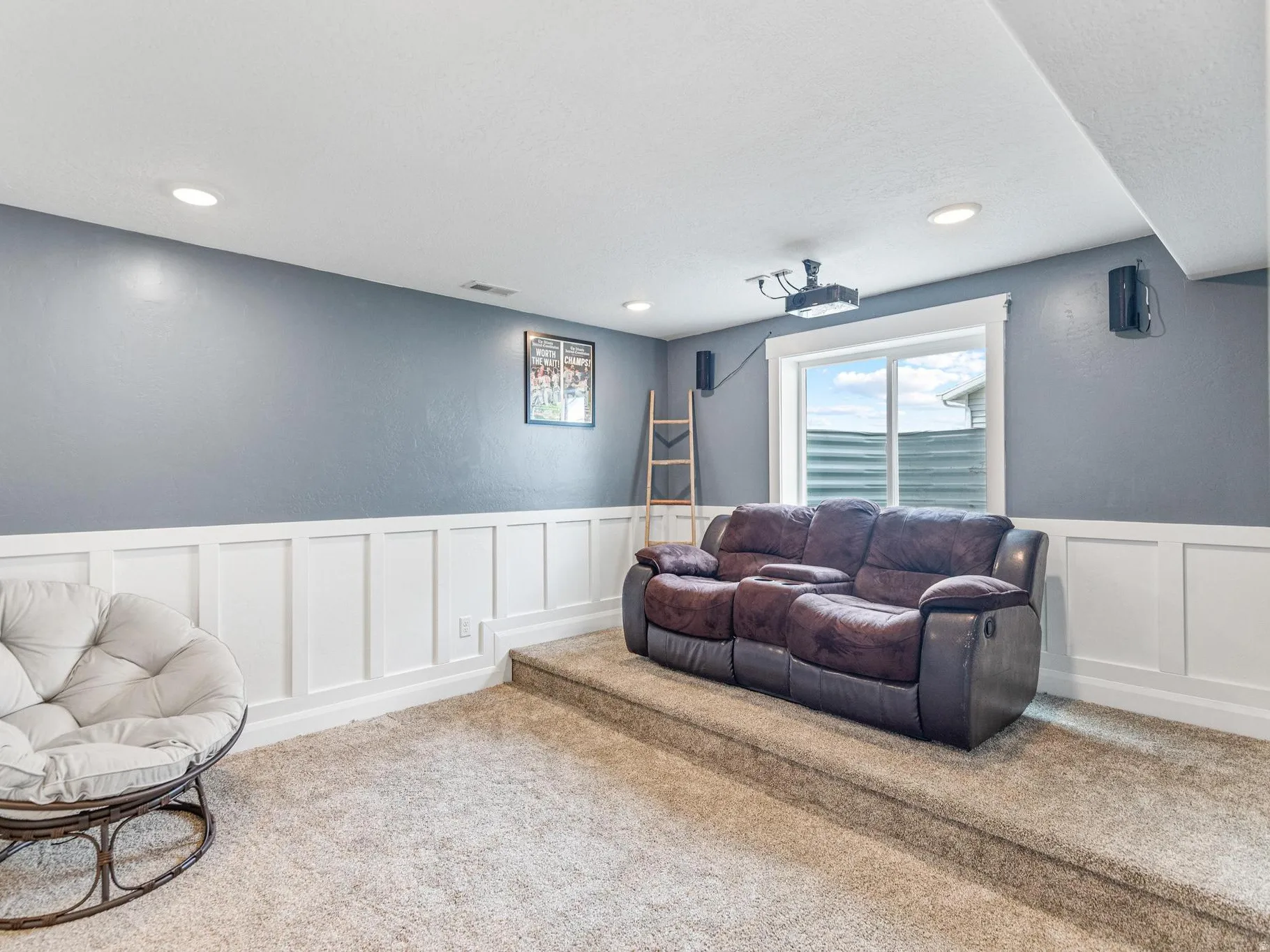 Living area featuring a decorative wall, wainscoting, carpet floors, and recessed lighting