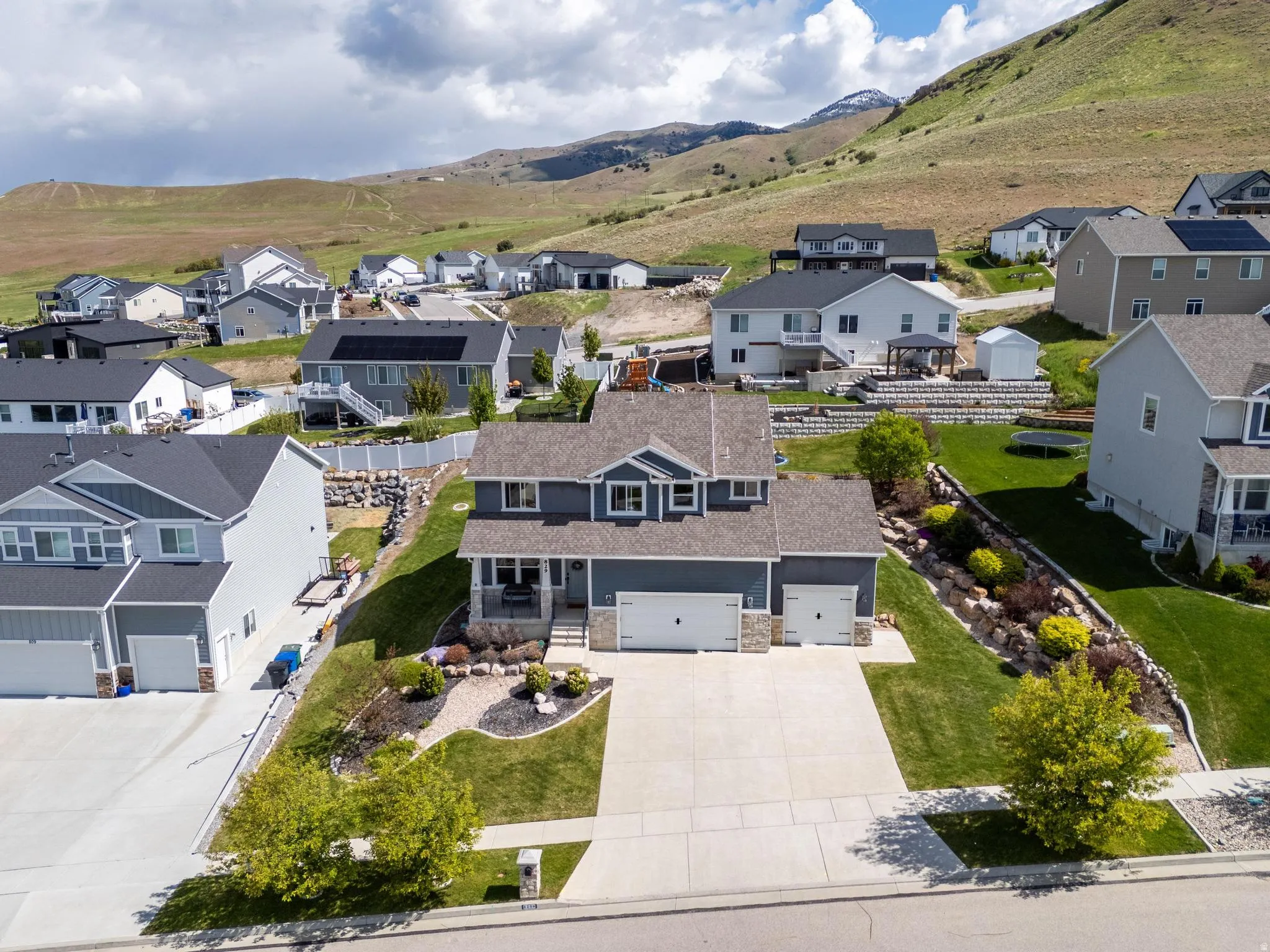 Two-story residence featuring a two-car garage, stone veneer accents, and a covered front porch