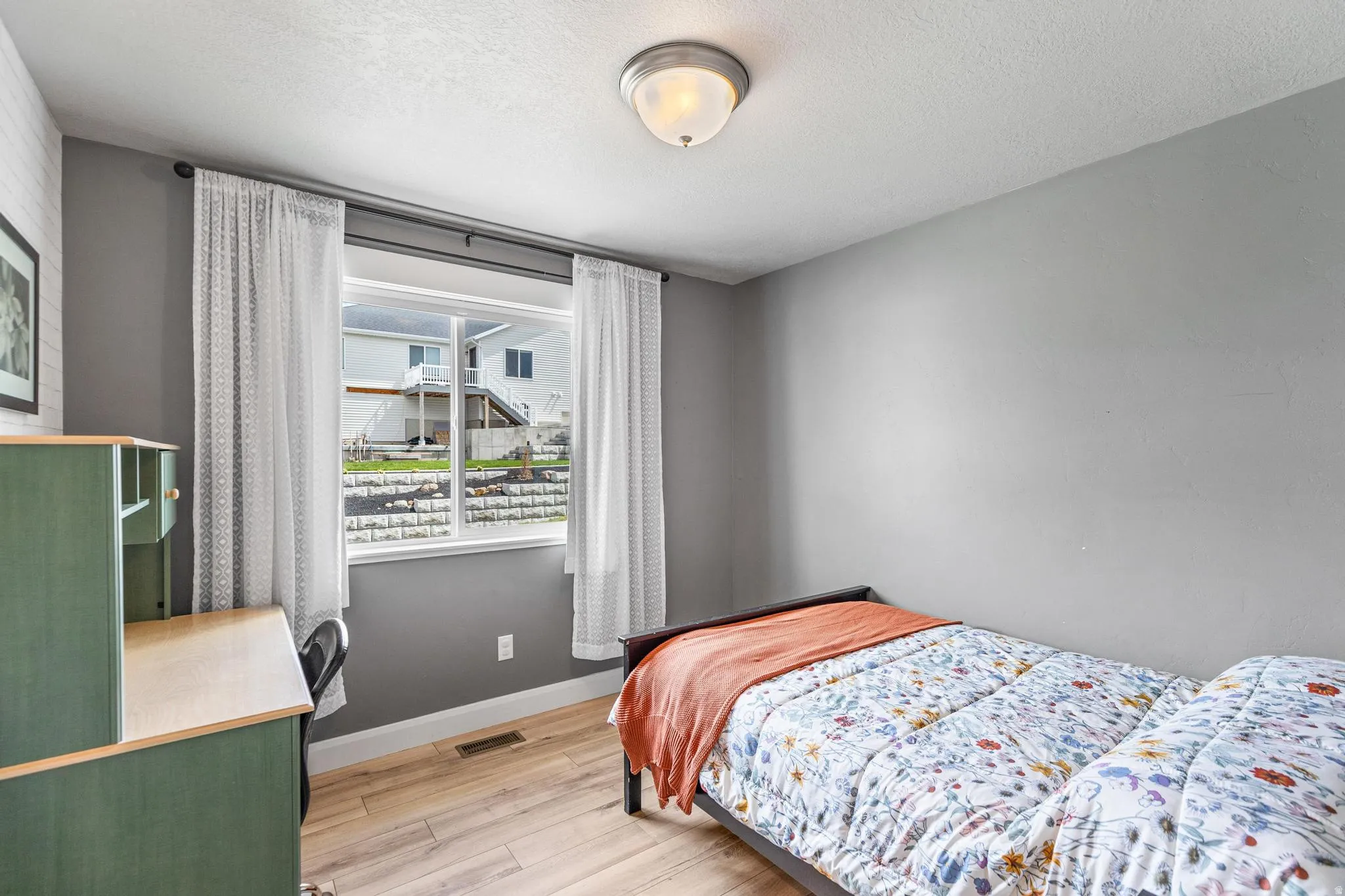 Bedroom featuring light wood-type flooring and a textured ceiling